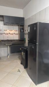 a kitchen with a black refrigerator and a stove at Casa Borges leal in Santarém