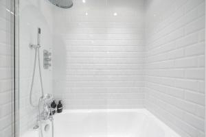 a white bathroom with a shower and a tub at Idyllic Waterside Cottage in Mid Devon in Tiverton +19 photos