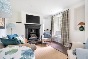 a living room with a fireplace and a tv at Idyllic Waterside Cottage in Mid Devon in Tiverton