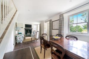 a dining room and living room with a table and chairs at Idyllic Waterside Cottage in Mid Devon in Tiverton