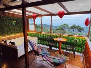 a balcony with a hammock and a table and hearts at Glamping STELAR VILLA EL EDEN in Cali