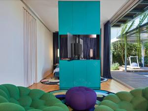a living room with a tv and a room with green at כוכב קיסר in Caesarea
