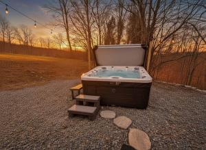 a jacuzzi tub with a bench in a field at Chic Renovated Chalet with Private Pond in Roscoe