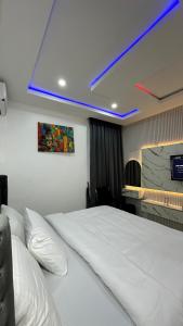a bedroom with a white bed and a blue light at TWR Abuja Partner #Blessing in Abuja