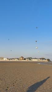 a shadow of a person flying a kite on a beach at Les 3 conserveries in Le Crotoy