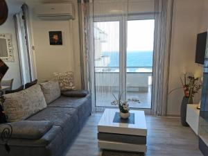 a living room with a couch and a large window at Golf & Meer - Appartment im Skiper Resort in Crveni Vrh
