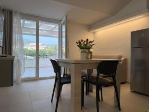a kitchen with a table with chairs and a refrigerator at Ferraro Apartments in Campora San Giovanni