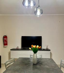 a dining room with a table with a vase of flowers at Sirè House in LʼAquila