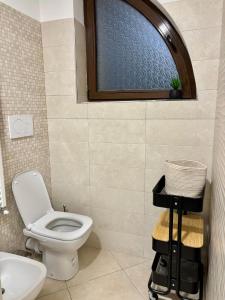 a bathroom with a toilet and a window at Sirè House in LʼAquila +14 photos