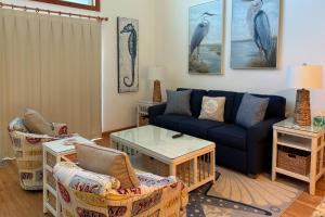 a living room with a blue couch and chairs at 4110 - Coop's Cottage in Duck