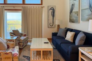 a living room with a blue couch and a table at 4110 - Coop's Cottage in Duck