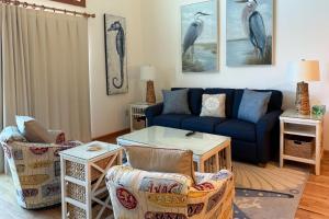 a living room with a blue couch and chairs at 4110 - Coop's Cottage in Duck +24 photos