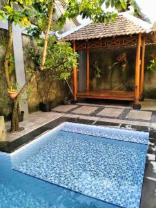 a swimming pool in front of a gazebo at Sabi House Sardjono in Yogyakarta