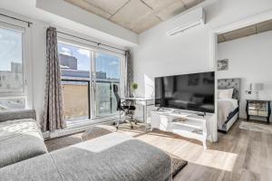 a living room with a large window and a tv at Suites Caiman in Quebec City