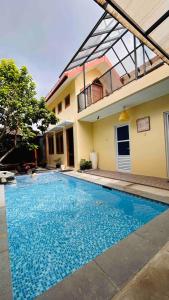 a swimming pool in front of a house at Sabi House Sardjono in Yogyakarta