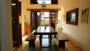 a dining room with a wooden table and benches at Sabi House Sardjono in Yogyakarta