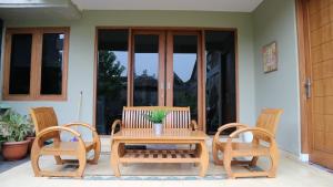 a wooden table and chairs on a patio at Sabi House Sardjono in Yogyakarta +8 photos