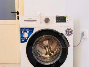 a white washing machine with a silver door at Arc Apartment Family - City Center in Divjakë