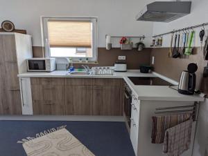 a small kitchen with a sink and a microwave at Gemütliches Zimmer in der modernen Ferienwohnung Schwalbennest im EG links in Sachsenheim