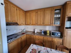 a kitchen with wooden cabinets and a counter top at Residenza Cornicello in Bardolino +50 photos