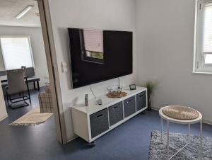 a living room with a flat screen tv on a wall at Gemütliches Zimmer in der modernen Ferienwohnung Schwalbennest im EG links in Sachsenheim