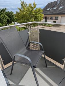 a black chair sitting on top of a balcony at Gemütliches Zimmer in der modernen Ferienwohnung Schwalbennest im EG links in Sachsenheim