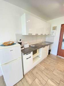 a kitchen with white cabinets and a white refrigerator at - Le Belvédère - in Turckheim