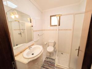 a bathroom with a toilet and a sink and a shower at Paul do Mar view in Paul do Mar +25 photos
