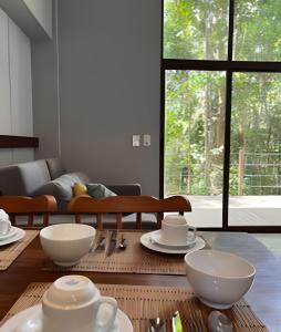 a living room with a table with bowls on it at Itacaré Ecolodge - Experiencia de Imersão na Mata Atlântica in Itacaré
