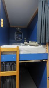 a bunk bed in a small room with a blue wall at Лидер Хаус хостел in Varna City +26 photos