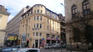 un grand bâtiment dans une rue de la ville avec des voitures dans l'établissement The Central Post Apartments, à Sofia