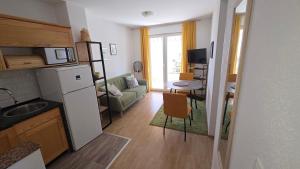 a kitchen and living room with a couch and a table at Rooms-Sobe Haus Magdalena Krk in Krk
