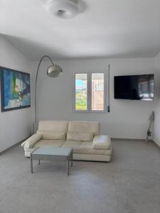 a white living room with a couch and a tv at Villa Lina in Agrigento