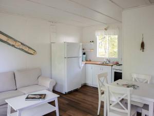 a kitchen with a white refrigerator and a table and chairs at Beachside on Lake Muskoka in Port Carling
