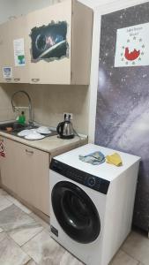 a kitchen with a washing machine and a sink at Лидер Хаус хостел in Varna City