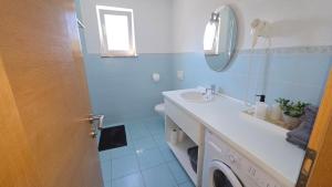 a bathroom with a sink and a washing machine at Rooms-Sobe Haus Magdalena Krk in Krk +43 photos