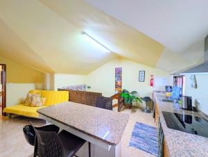 a living room with a table and a yellow couch at Paul do Mar view in Paul do Mar