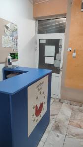 a blue desk with a sign in front of a door at Лидер Хаус хостел in Varna City