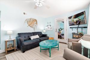 a living room with a couch and a table at Coastal Condo Steps from the Beach in Gulf Shores
