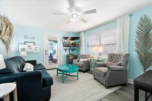a living room with blue walls and a couch and chairs at Coastal Condo Steps from the Beach in Gulf Shores