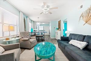 a living room with a couch and a table at Coastal Condo Steps from the Beach in Gulf Shores