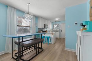 a kitchen with blue walls and a blue table and stools at Coastal Condo Steps from the Beach in Gulf Shores +22 photos