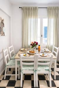 a dining room with a table and chairs with food on it at Veneziana Liston view apt in Corfu