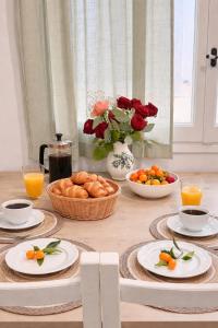 a table with plates of food and bowls of oranges at Veneziana Liston view apt in Corfu