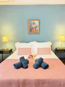 a bed with two blue pillows on top of it at Veneziana Liston view apt in Corfu
