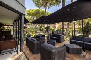 a patio with chairs and umbrellas on a deck at CASA MAJOR Hotel & Appartamenti CERVIA in Cervia