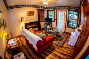 a living room with a red couch and a table at Cliff Cottage Inn, Downtown Bed & Breakfast in Eureka Springs