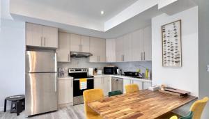 a kitchen with a wooden table and a refrigerator at Bentley Commons Fallsview - Luxury 4 Bedroom 4 Bath Townhouse in Niagara Falls