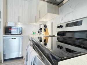 a kitchen with a stainless steel stove top oven at Bentley Commons Fallsview - Luxury 4 Bedroom 4 Bath Townhouse in Niagara Falls