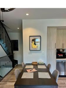 a dining room with a table and a kitchen at Bentley Commons Fallsview - Luxury 4 Bedroom 4 Bath Townhouse in Niagara Falls +24 photos